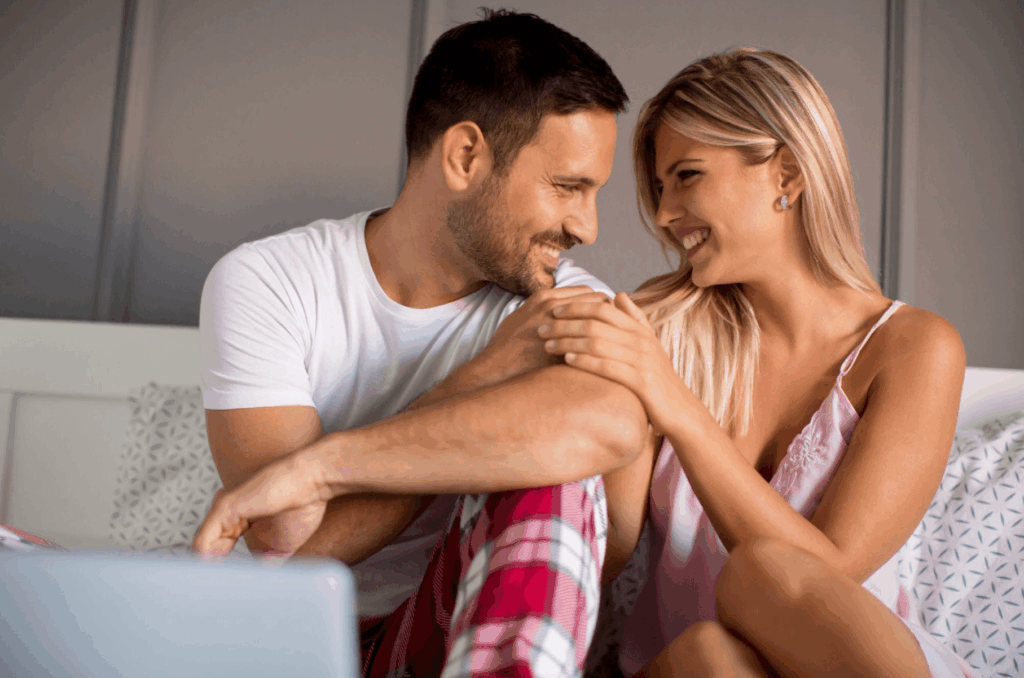 Smiling couple holding hands and sharing a close moment, representing healthy intimacy and relationships affected by Peyronie’s disease.