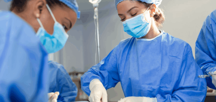 Surgical team carrying out an operation in a hospital theatre, representing why some men look for alternatives to surgery for Peyronie’s disease.